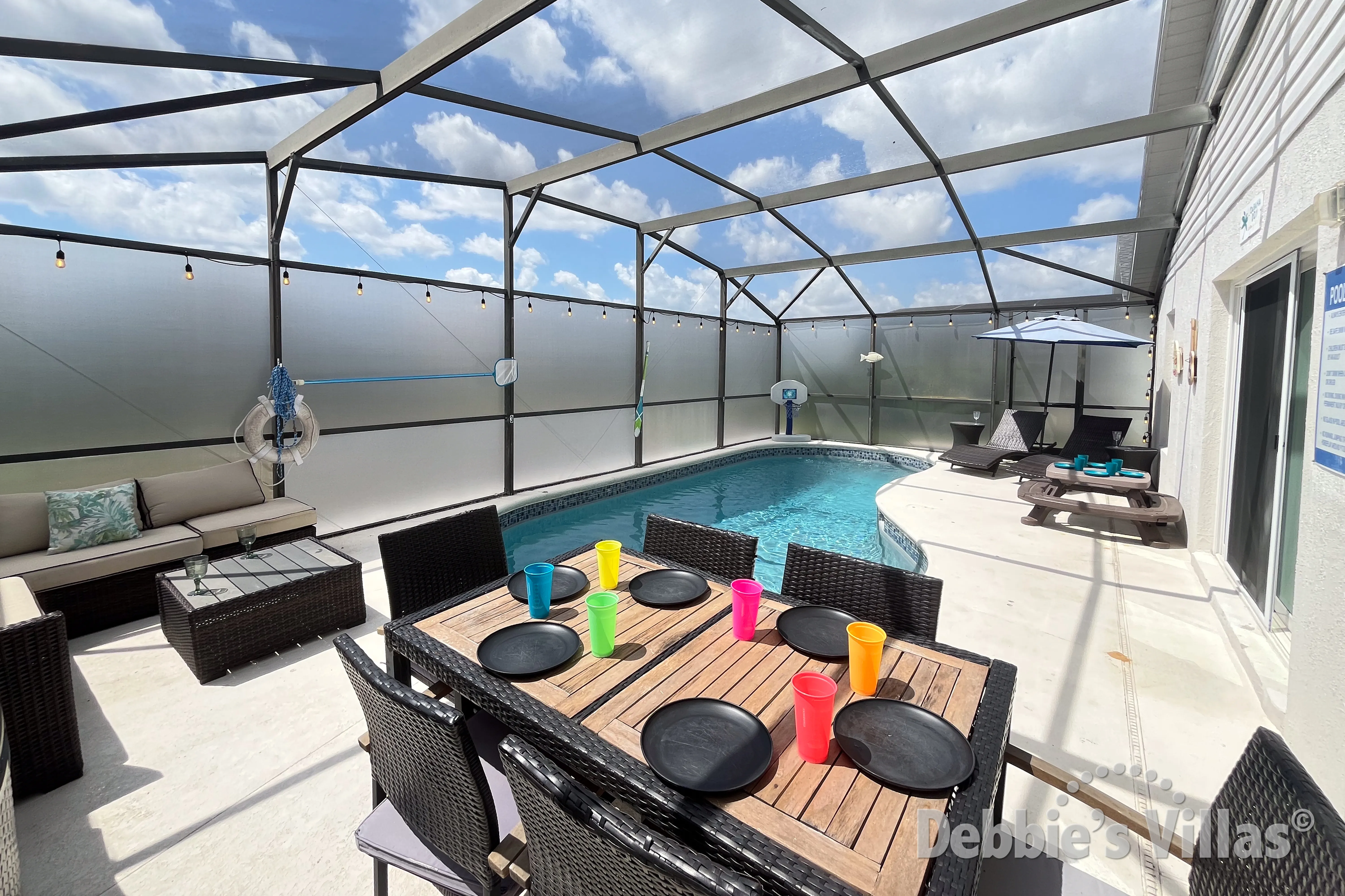 Enjoy an alfresco meal at the poolside table at this Kissimmee vacation villa 