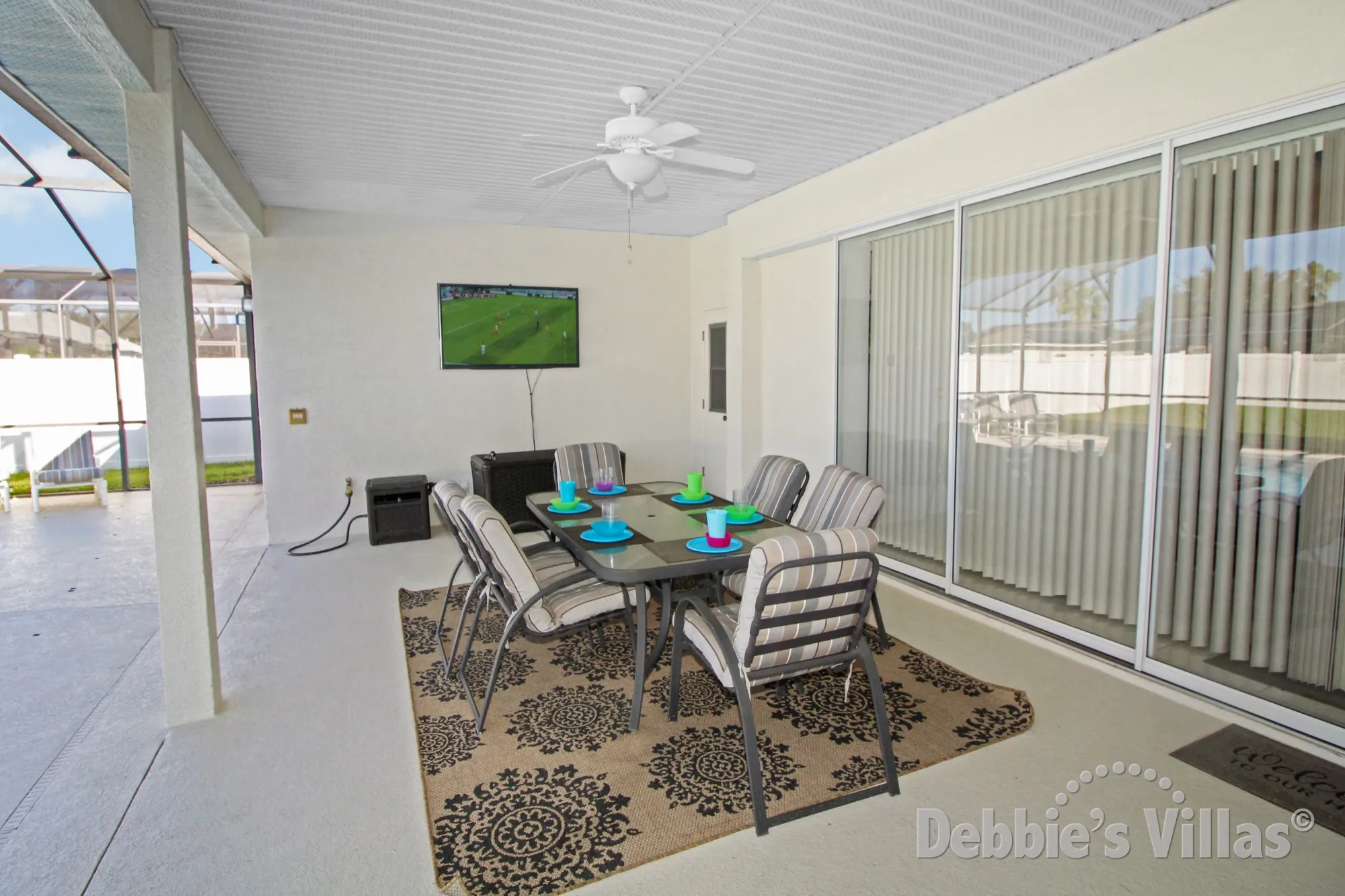 Outside dining area with pool deck TV