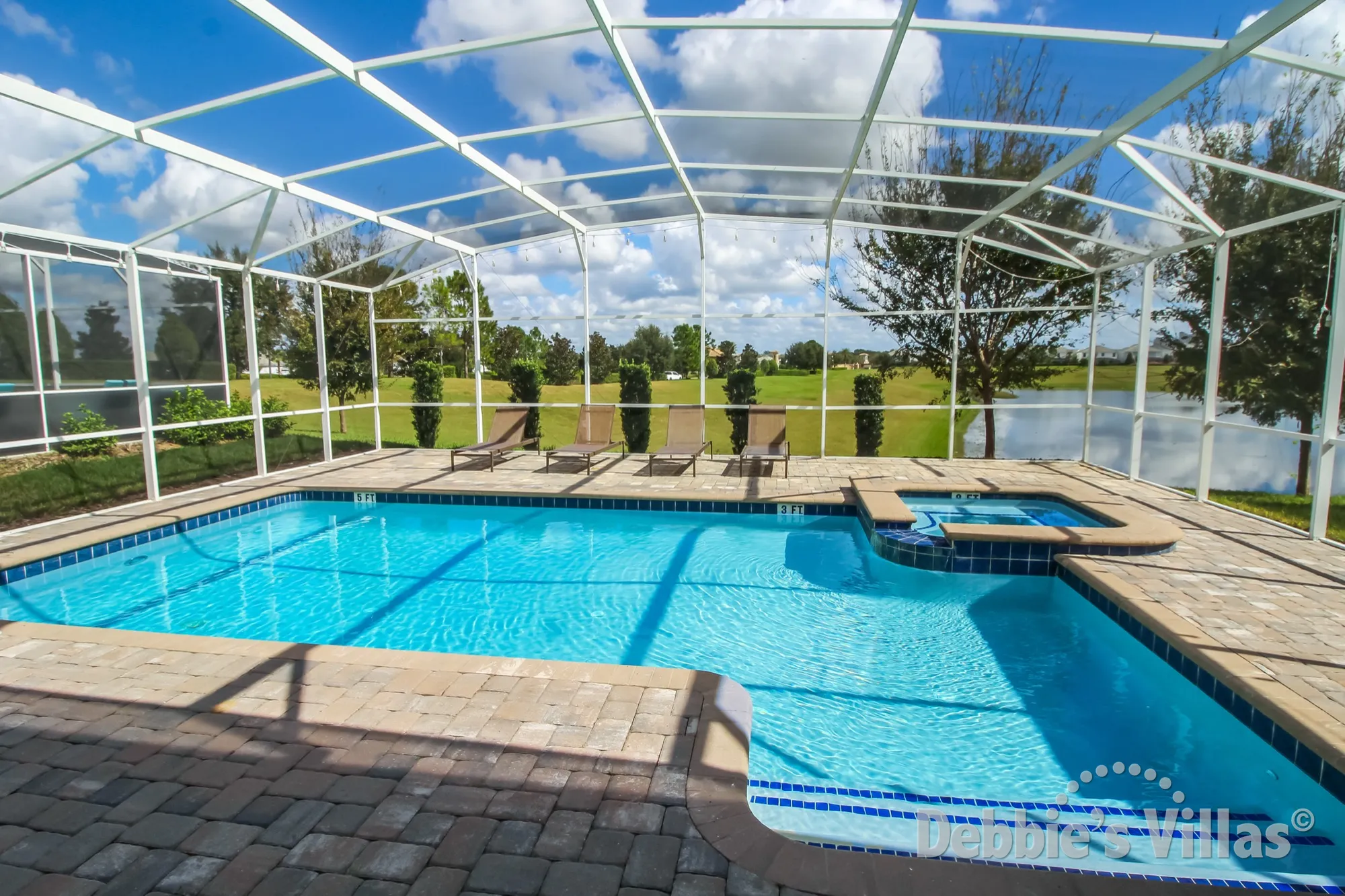 Sun-drenched pool and spa with lake view at this ChampionsGate vacation villa