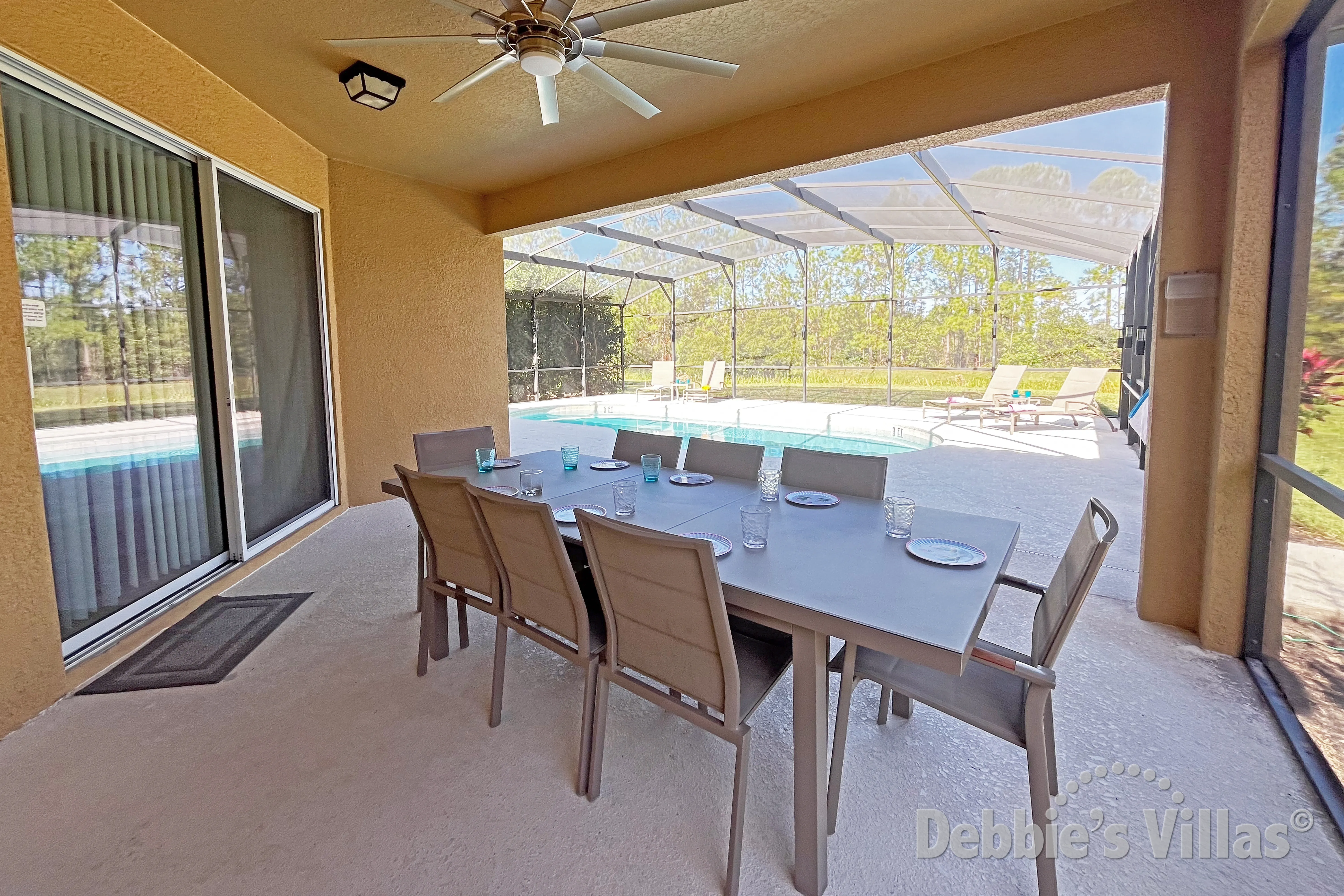 Dine alfresco at the covered dining area on the pool deck at this Davenport vacation villa
